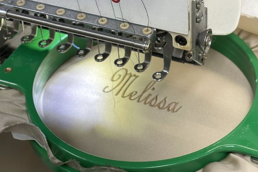 Embroidery machine stitching a name onto a garment lining